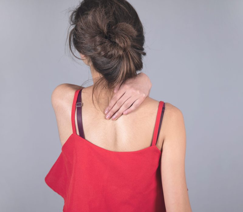 woman hand in ache back on gray background